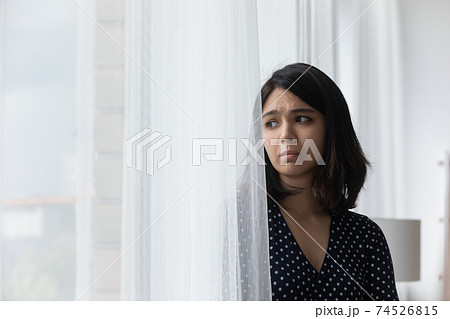 Sad young asian woman stand by window think of loneliness 74526815
