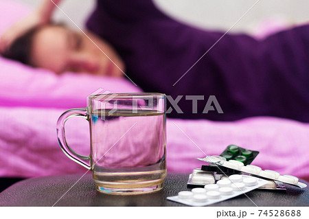 A woman feels sick while lying on the bed. A woman feels sick while lying on the bed. 74528688