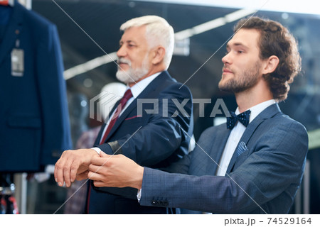 Two elegant men choosing costumes. 74529164