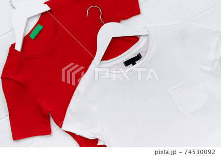 Flat lay top view womens t-shirts on hanger on white background Flat lay top view womens t-shirts on hanger on white background 74530092