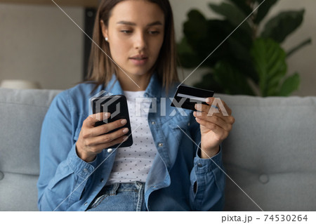 Young lady making purchase at internet shop using cell Young lady making purchase at internet shop using cell 74530264