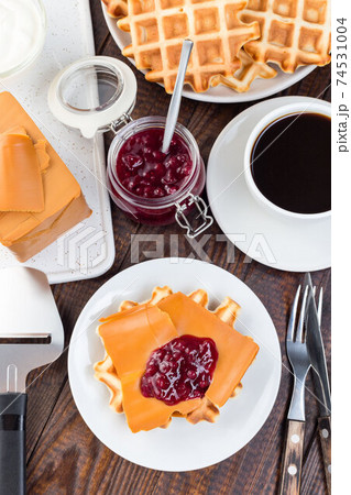 Homemade waffles with norwegian brown cheese and lingon jam, on wooden background, vertical, top view Homemade waffles with norwegian brown cheese and lingon jam, on wooden background, vertical, top view 74531004