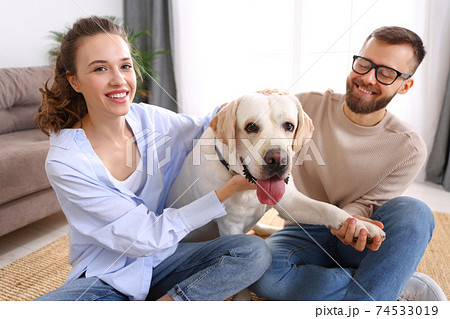 happy married couple playing with their favorite pet dog   at home happy married couple playing with their favorite pet dog   at home 74533019