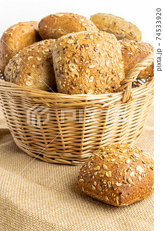 Cut bread. Fresh loaf of rustic traditional bread with wheat grain ear or spike plant on linen texture background. Rye bakery with crusty loaves and crumbs. Bio ingredients, very healthy seeds. Cut bread. Fresh loaf of rustic traditional bread with wheat grain ear or spike plant on linen texture background. Rye bakery with crusty loaves and crumbs. Bio ingredients, very healthy seeds. 74533920