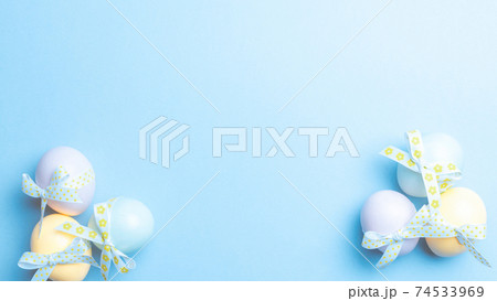 Easter eggs isolated. Colorful egg with tape ribbon on pastel blue background in Happy Easter decoration. Flat lay, top view. Easter eggs isolated. Colorful egg with tape ribbon on pastel blue background in Happy Easter decoration. Flat lay, top view. 74533969