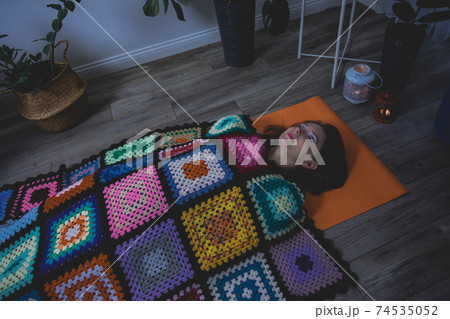 Woman lying in Shavasana, resting after yoga practice Woman lying in Shavasana, resting after yoga practice 74535052