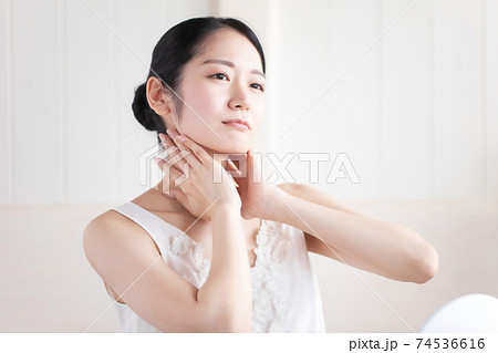 首を触る女性の写真素材