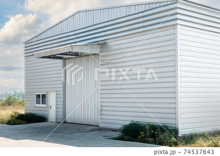 Steel Shutter Roller Door of Factory Warehouse Workshop for Materials Storage, Front View of Rolling Metal Doors for Access and Security. Gate Building Structure of Warehouses for Store 74537643