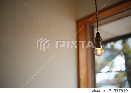 ナチュラルライフを実践している若夫婦が建てた家の窓辺に吊るされた裸電球 74537910