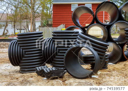 Plastic PVC pipes stacked in rows at a construction site on reconstruction of the city drain system Plastic PVC pipes stacked in rows at a construction site on reconstruction of the city drain system 74539577