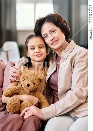 Affectionate mature brunette woman and her adorable little granddaughter 74539717