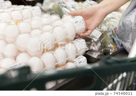 スーパーで卵を買う女性買い物客手元 74540011
