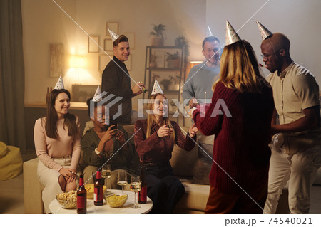 Happy young intercultural friends congratulating smiling girl on her birthday 74540021