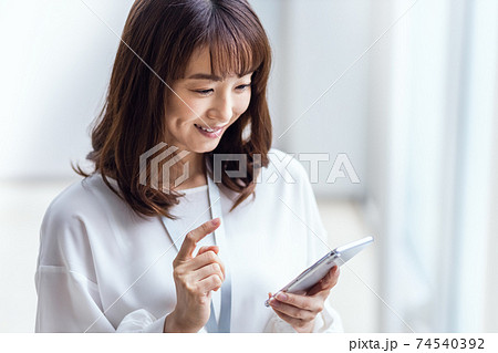 笑顔でスマホを操作する女性 74540392