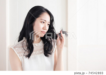 髪の毛を触る女性（困る） 74542893