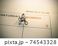 Girl riding bicycle with vintage weekend calendar 74543328