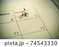 Girl riding bicycle with vintage weekend calendar 74543330