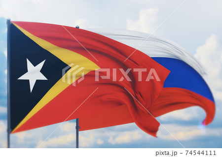 Waving Russian flag and flag of East Timor. Closeup view, 3D illustration. 74544111