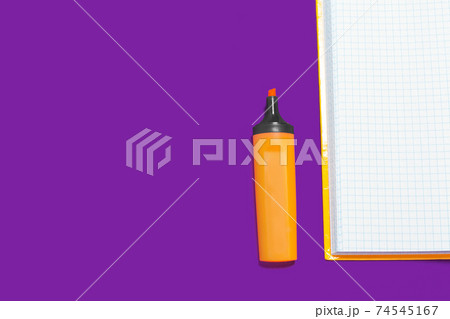 orange marker near a copybook orange marker near a copybook 74545167