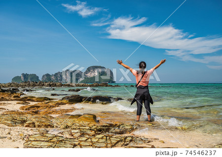 Tropical islands view with woman tourist looking at ocean blue sea water and white sand beach at Bamboo Island, Krabi Thailand nature landscape Tropical islands view with woman tourist looking at ocean blue sea water and white sand beach at Bamboo Island, Krabi Thailand nature landscape 74546237