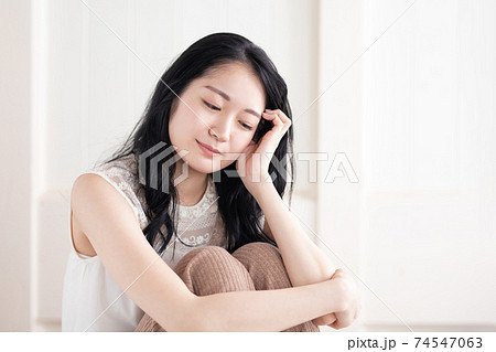 部屋で落ち込む女性の写真素材