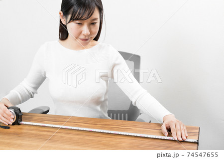 メジャーで測る座った女性 メジャーで測る座った女性 74547655