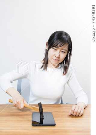 ハンマーでタブレットを壊そうとしている女性 ハンマーでタブレットを壊そうとしている女性 74549291