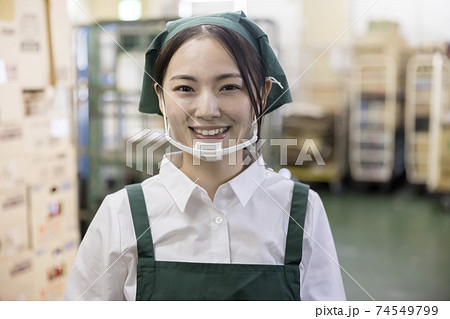スーパーのバックヤードでマウスシールドをしたカメラ目線女性従業員 スーパーのバックヤードでマウスシールドをしたカメラ目線女性従業員 74549799