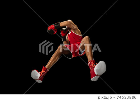 Young african-american boxer in action, motion isolated on black background, look from the bottom. Concept of sport, movement, energy and dynamic. 74553886