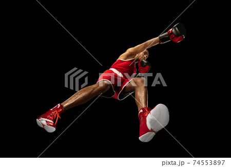 Young african-american boxer in action, motion isolated on black background, look from the bottom. Concept of sport, movement, energy and dynamic. Young african-american boxer in action, motion isolated on black background, look from the bottom. Concept of sport, movement, energy and dynamic. 74553897