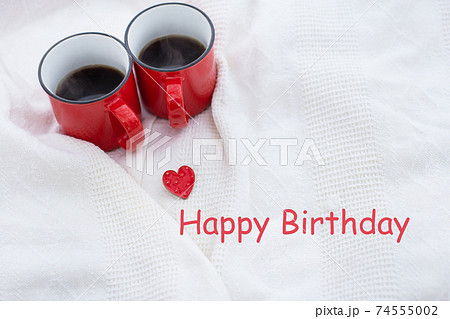 Romantic still life, two red cups of coffee on a white plaid. Happy birthday lettering, holiday card. Romantic still life, two red cups of coffee on a white plaid. Happy birthday lettering, holiday card. 74555002