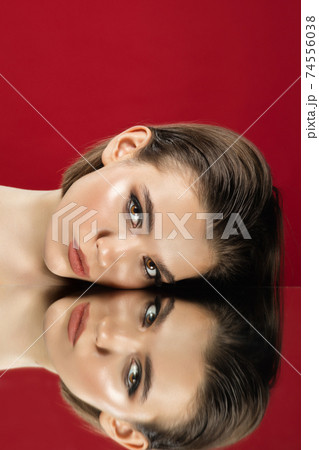 Portrait of female fashion model with reflections on mirrors around her face. Style and beauty concept. Close up. 74556038