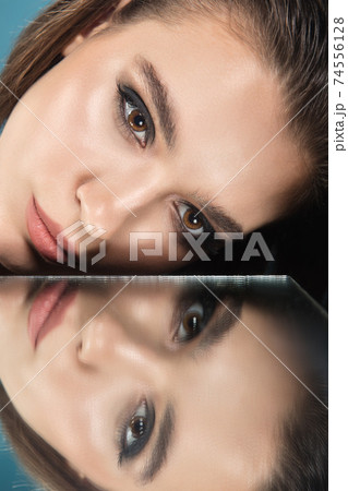 Portrait of female fashion model with reflections on mirrors around her face. Style and beauty concept. Close up. Portrait of female fashion model with reflections on mirrors around her face. Style and beauty concept. Close up. 74556128