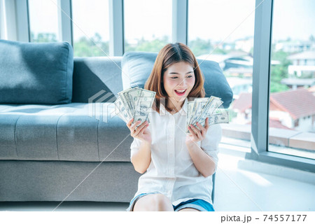 Happy young asian woman holding dollar money and throw in the air celebrate happiness dance wealth Happy young asian woman holding dollar money and throw in the air celebrate happiness dance wealth 74557177