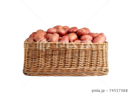 Basket with potatoes with red peel on a white background, isolate. Organic natural vegetables, farming 74557368