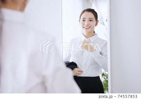 鏡の前で身支度をする若いビジネスウーマン  74557853