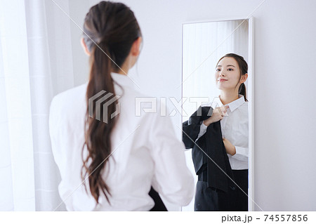 鏡の前で身支度をする若いビジネスウーマン  74557856