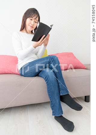 ソファに座って本を読む女性の写真素材 [74558045] - PIXTA