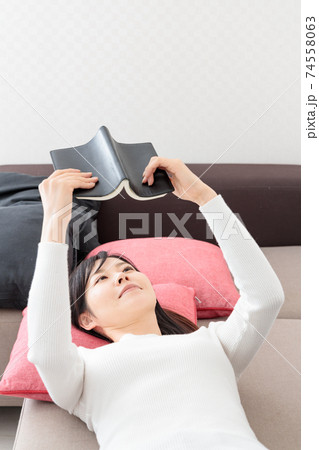 ソファに寝転んで本を読む女性 ソファに寝転んで本を読む女性 74558063