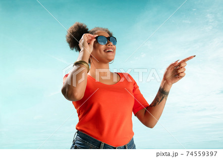 Portrait of female fashion model on blue sky background. Style and beauty concept, bright appearance 74559397