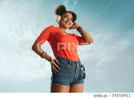 Portrait of female fashion model on blue sky background. Style and beauty concept, bright appearance Portrait of female fashion model on blue sky background. Style and beauty concept, bright appearance 74559451