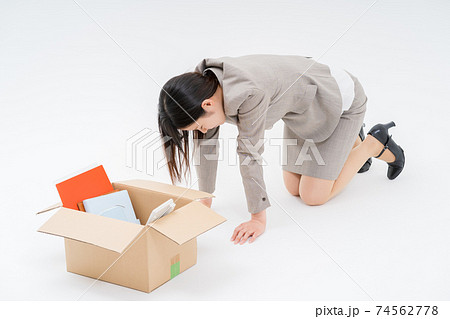 解雇となり私物を箱に詰めて床に崩れおちるビジネスウーマン 74562778