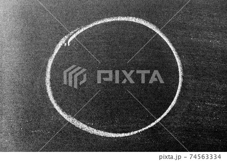 White color chalk hand drawing in circle or oval shape on black board background 74563334
