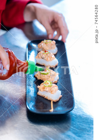 Chef plating finished appetizer 74564280
