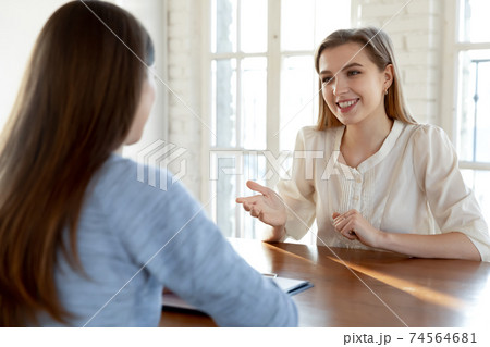 Happy millennial female job seeker making self-presentation to employer. Happy millennial female job seeker making self-presentation to employer. 74564681
