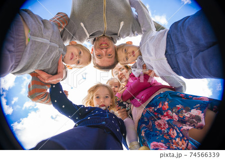 Friendly family hugs against the blue sky. Friendly family hugs against the blue sky. 74566339