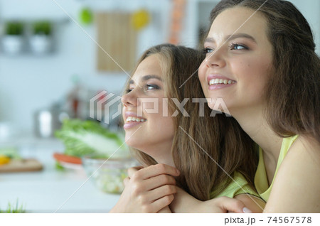 Portrait of a cute happy sisters hugging 74567578