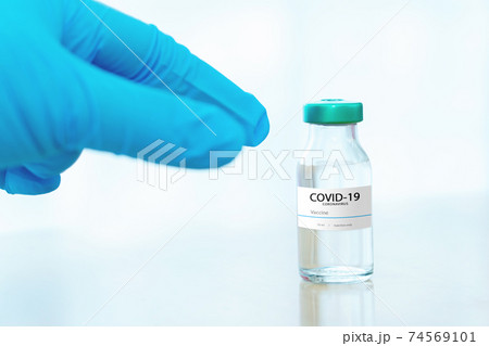 Development and creation of a coronavirus vaccine COVID-19 .Coronavirus Vaccine concept in hand of doctor blue vaccine jar. Vaccine Concept 74569101