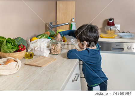 Little boy watcheing what is on kitchen table 74569994