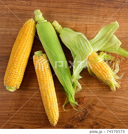 Fresh corn on cobs on rustic wooden table. Fresh corn on cobs on rustic wooden table. 74570573